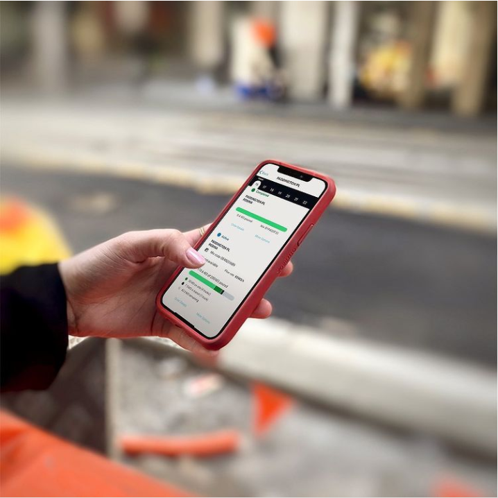Construction worker using a mobile device to track job site data