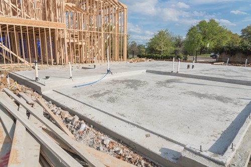 Concrete slab foundation (Slabcrete) poured on a construction site with timber framing structure in progress