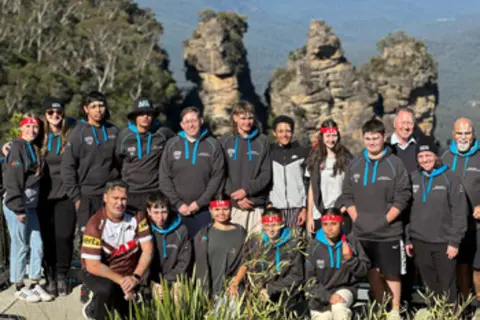 Group of Sticks to Stadium Program participants in New South Wales standing outdoors with rock formations in the background
