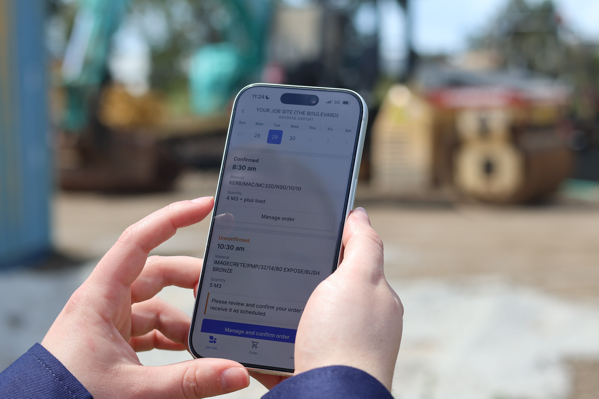 Construction worker on site using Heidelberg Materials' OnSite app to manage orders.