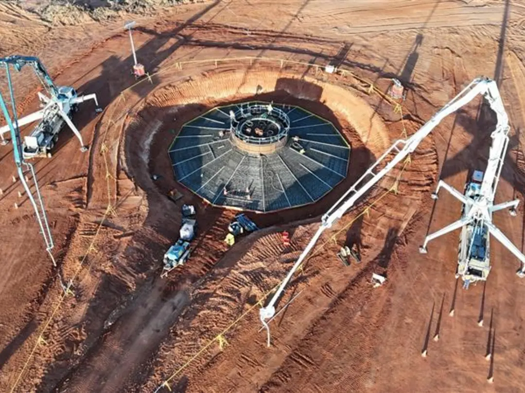 Aerial view of a concrete batch plant with mixing equipment and conveyor systems operating on a construction site.